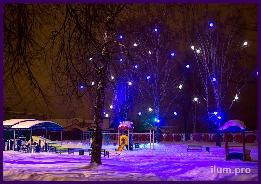 RGB прожекторы и разноцветные снежинки из дюралайта на деревьях на Новый год