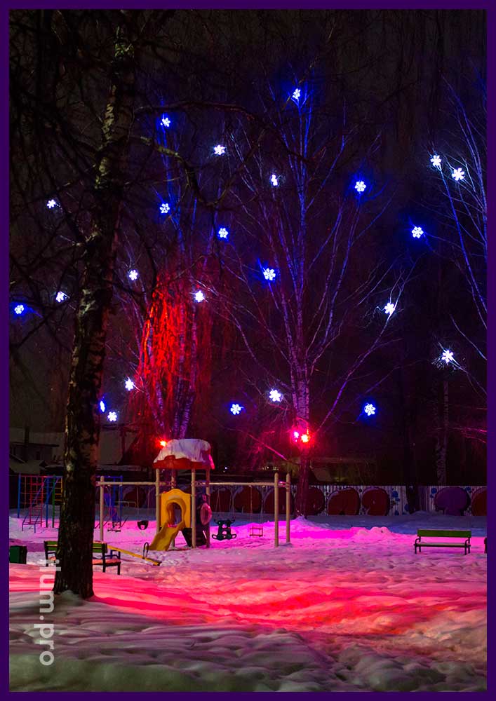 Подсветка деревьев на детской площадке снежинками и RGB прожекторами разных цветов