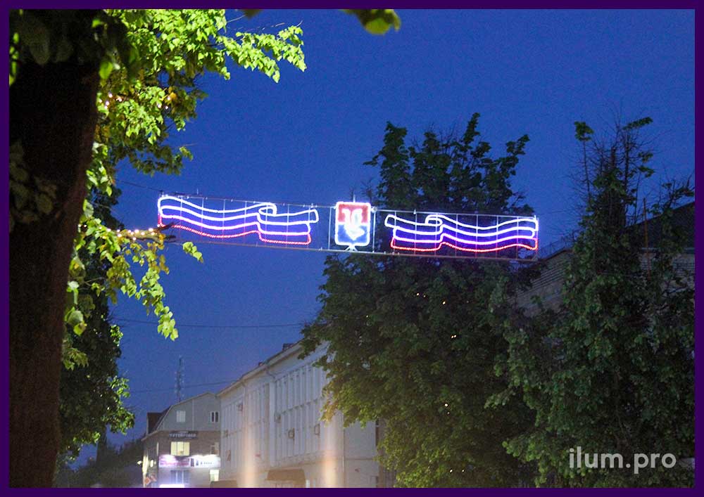 Перетяжка с гербом города и флагом России - праздничная иллюминация над дорогой