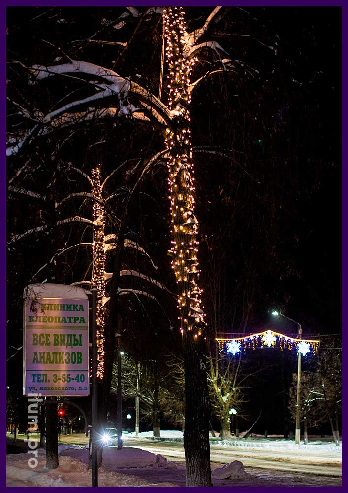 Новогодняя подсветка деревьев гирляндами тёпло-белого цвета