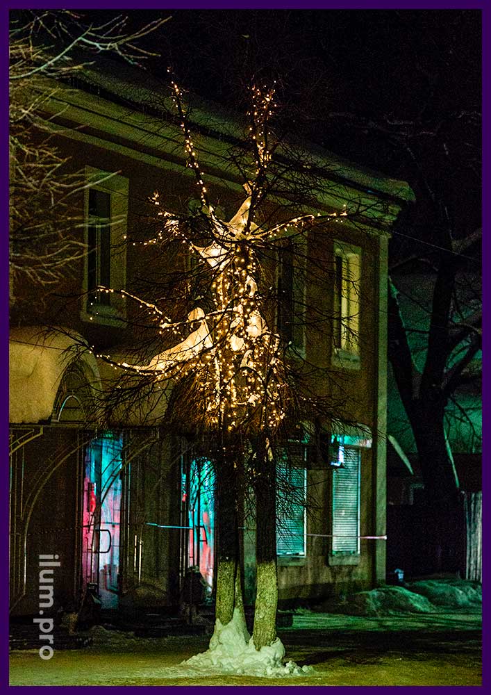 Новогодняя подсветка дерева гирляндами тёплых оттенков