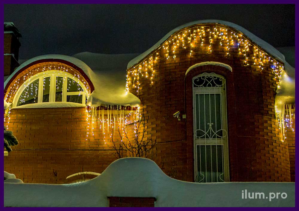 Бахрома тёпло-белая мерцающая на крыше кирпичного дома на Новый год