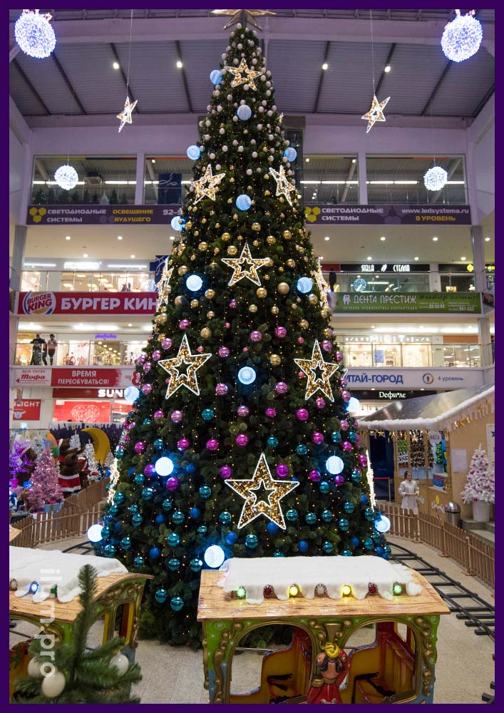 Украшение новогодней ёлки в атриуме торгового центра светящимися звёздами