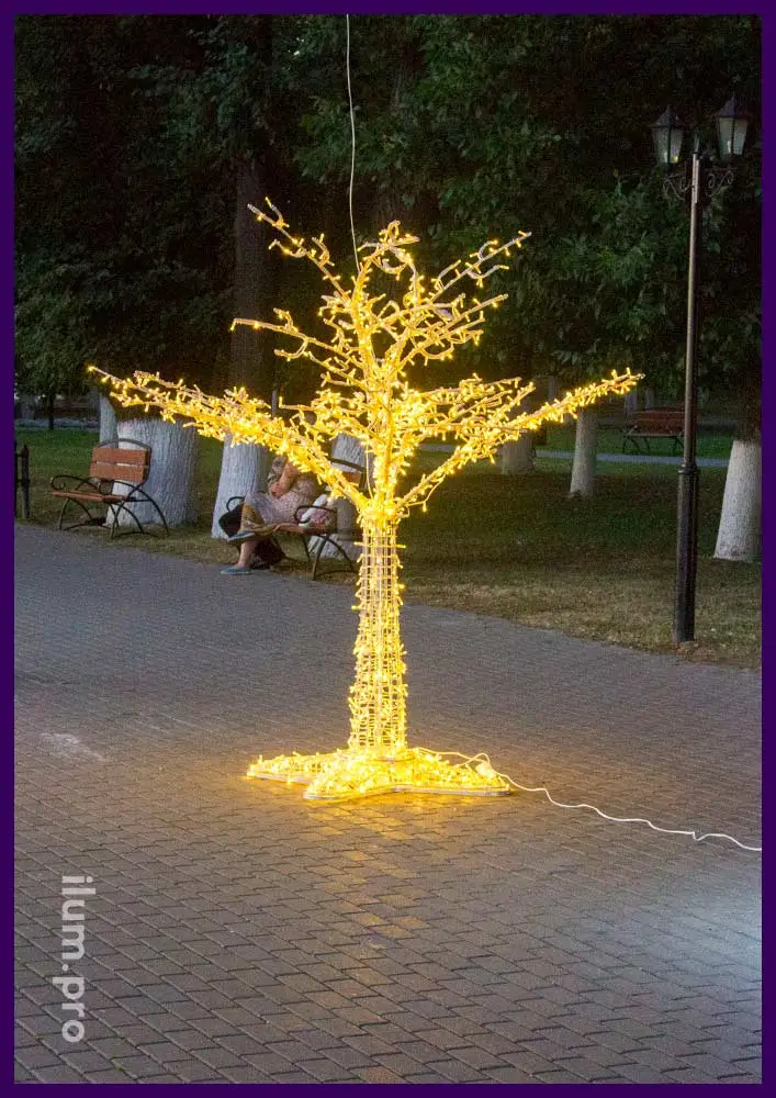 Светодиодное дерево вечером на дорожке в парке