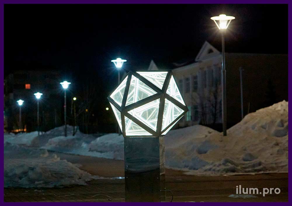 Металлический многоугольник с встроенной подсветкой на подиуме из серебряного АКП на городской площади