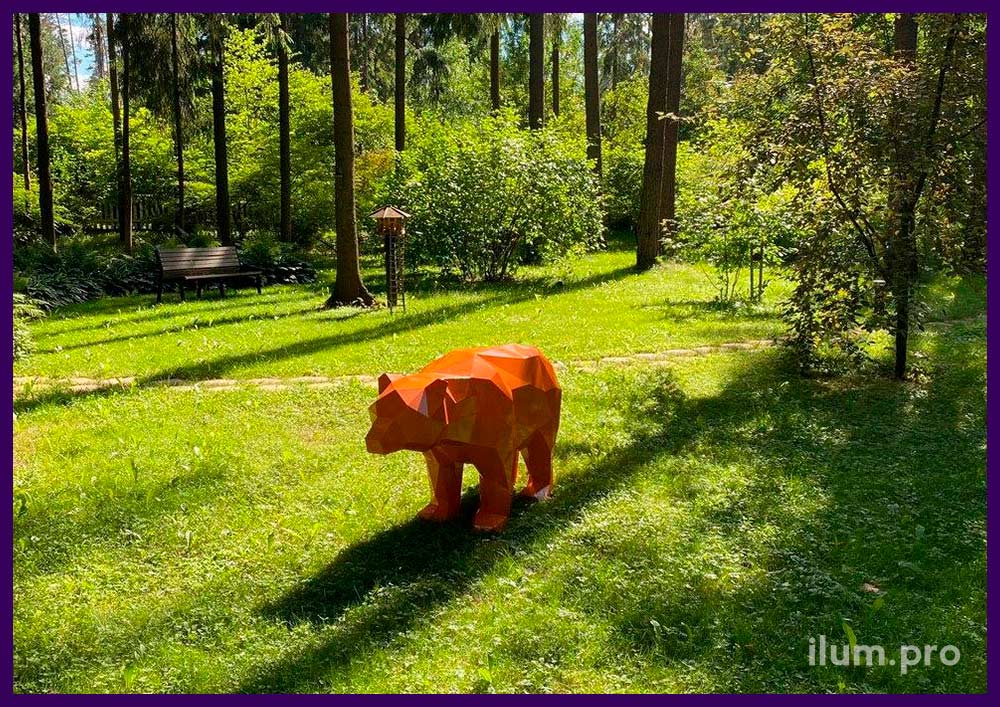 Медведь полигональный оранжевый из металла в саду на газоне
