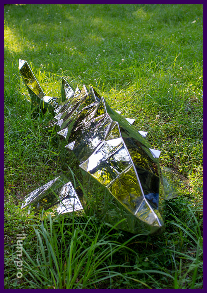 Полигональная металлическая фигура рыбы на траве