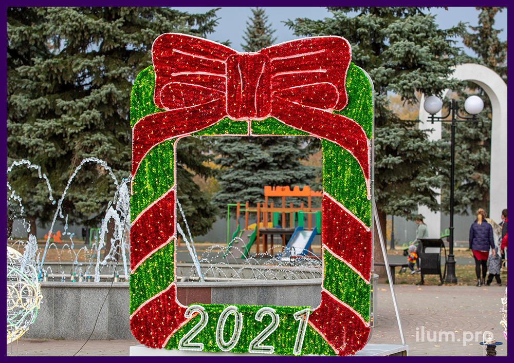 Фотозона новогодняя в виде арки с бантом и цифрами из мишуры и гирлянд