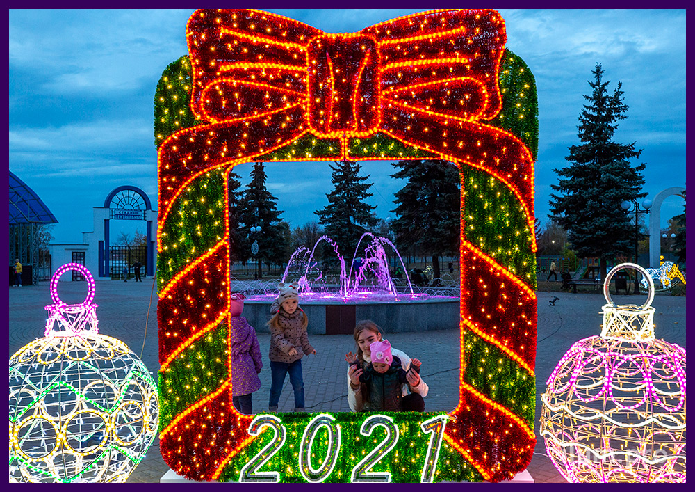 Разноцветная световая конструкция для украшения площади на Новый год в форме рамки с бантом