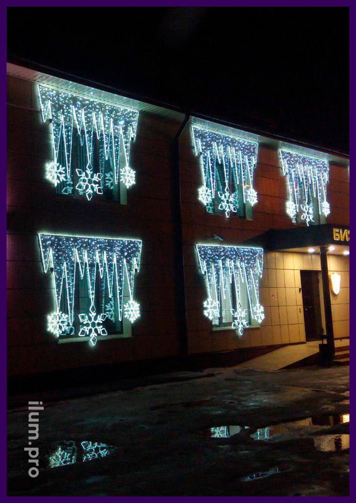 Белые консоли из светодиодных гирлянд и дюралайта на окнах офисного здания на Новый год
