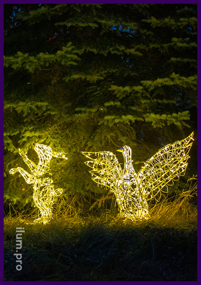 Световые фигуры зайцев и гусей с гирляндами в парке под деревьями