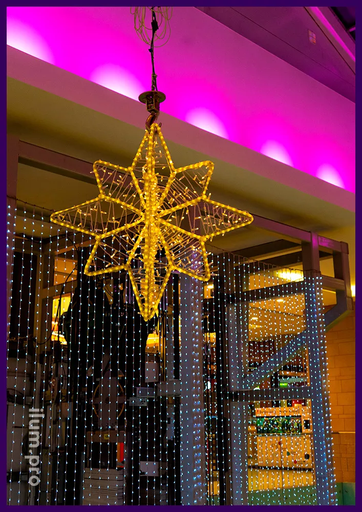 Звёзды и другая иллюминация с металлическим каркасом и гирляндами для украшения атриума торгового центра на Новый год