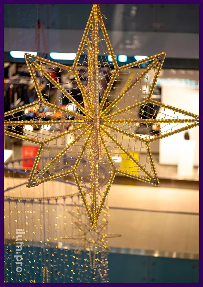 Новогодние украшения атриума подвесными звёздами и композициями в форме цилиндров из светодиодных гирлянд