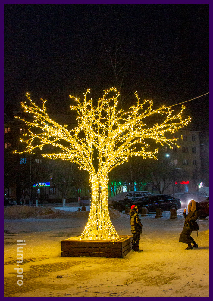Новогодние декорации в форме деревьев с гирляндами тёплых оттенков на алюминиевых ветках