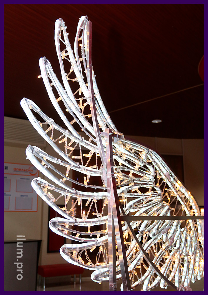 Украшение интерьера новогодней фотозоной в форме крыльев ангела с подсветкой