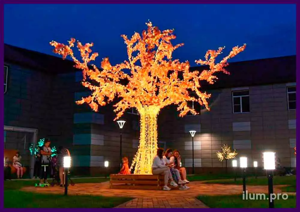 Светящееся дерево со скамейкой в основании и цветами с гирляндами на ветках