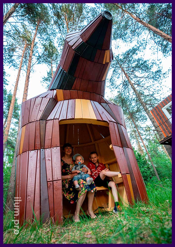 Деревянный домик в форме медведя - арт-объект в парке на детской площадке