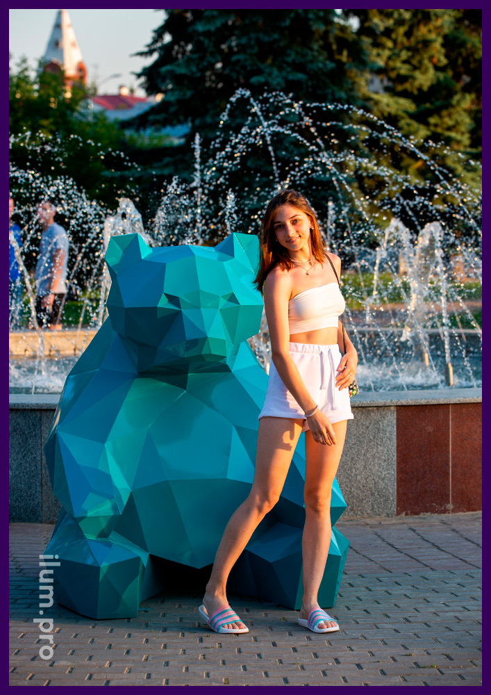 Ландшафтная полигональная скульптура медведя из стали рядом с фонтаном в парке