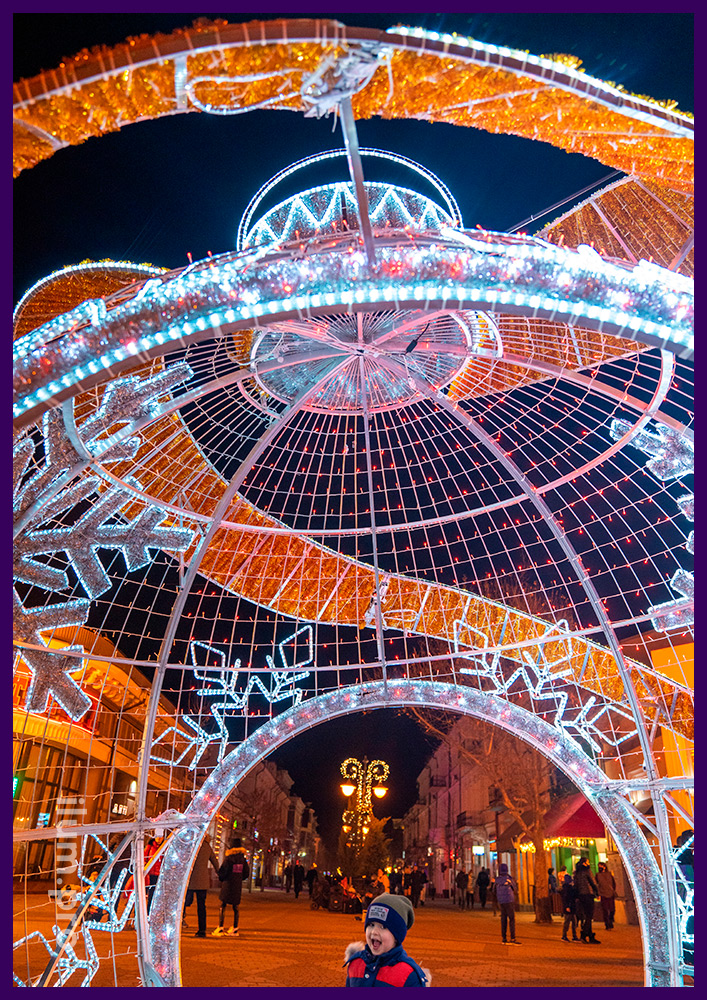 Фотозона в виде ёлочной игрушки с аркой из мишуры и гирлянд на площади в Крыму на Новый год