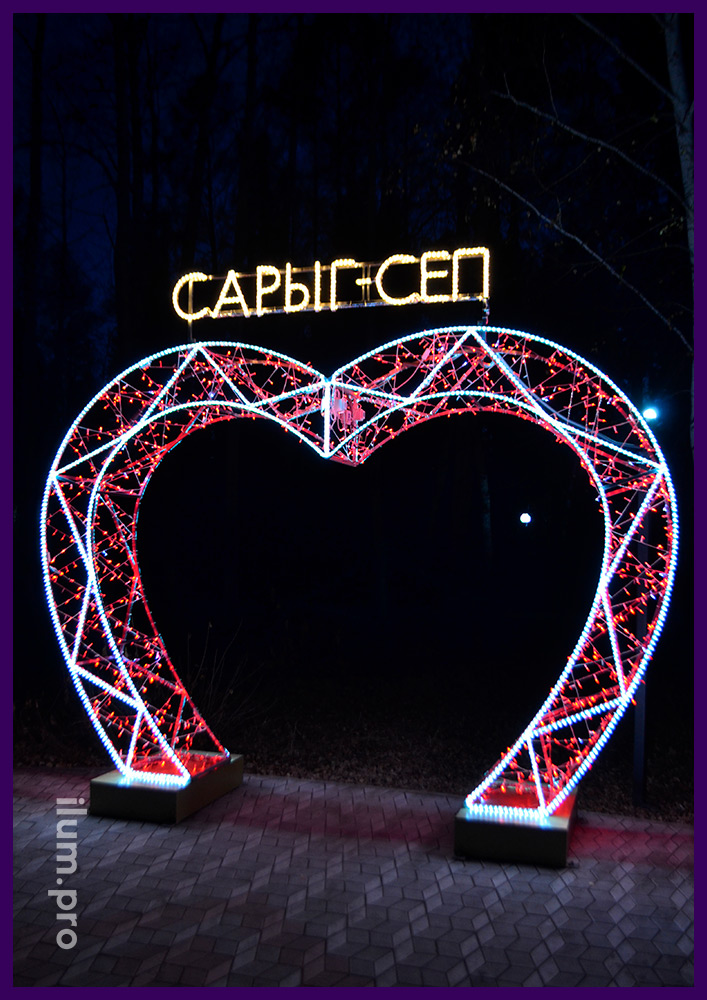 Арка Сарыг-Сеп в форме сердца с красными мерцающими гирляндами и контурами из белого дюралайта