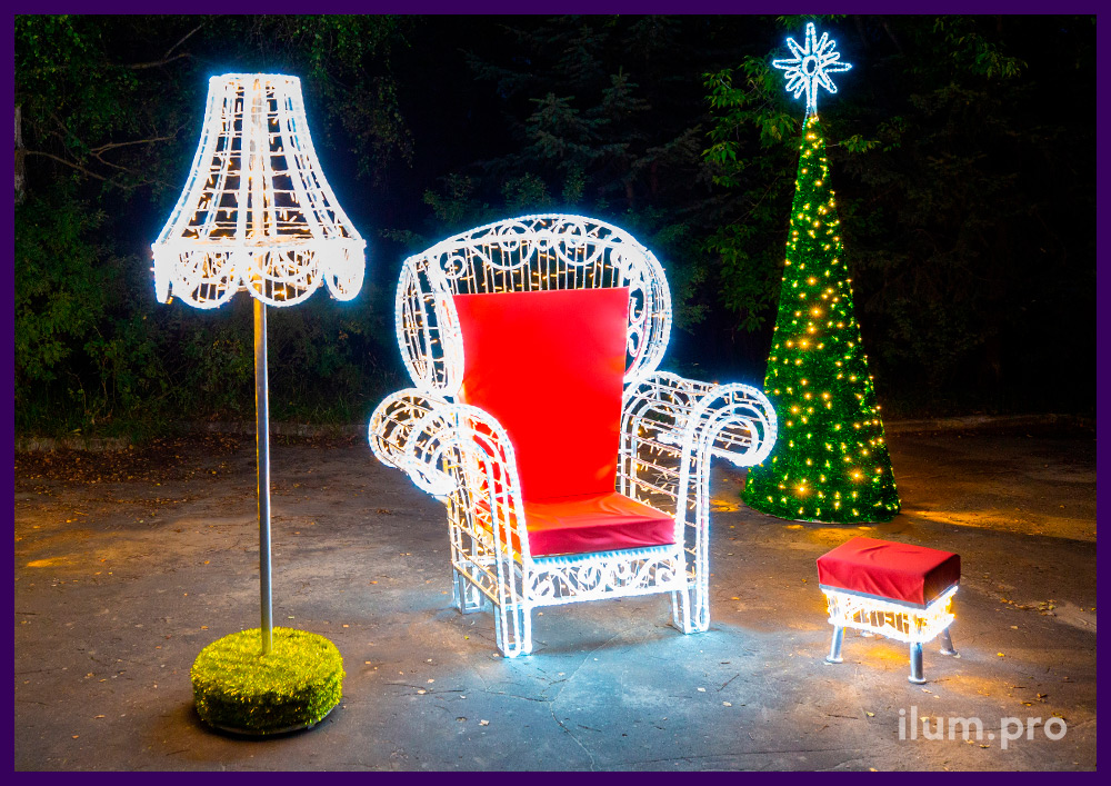 Новогодняя фотозона с конусами из мишуры с звёздами на макушке, красным креслом и пуфиком из гирлянд