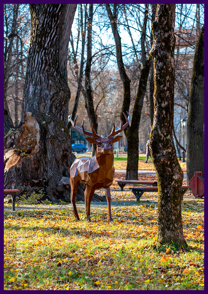 Металлическая полигональная фигура коричневого оленя в городском парке