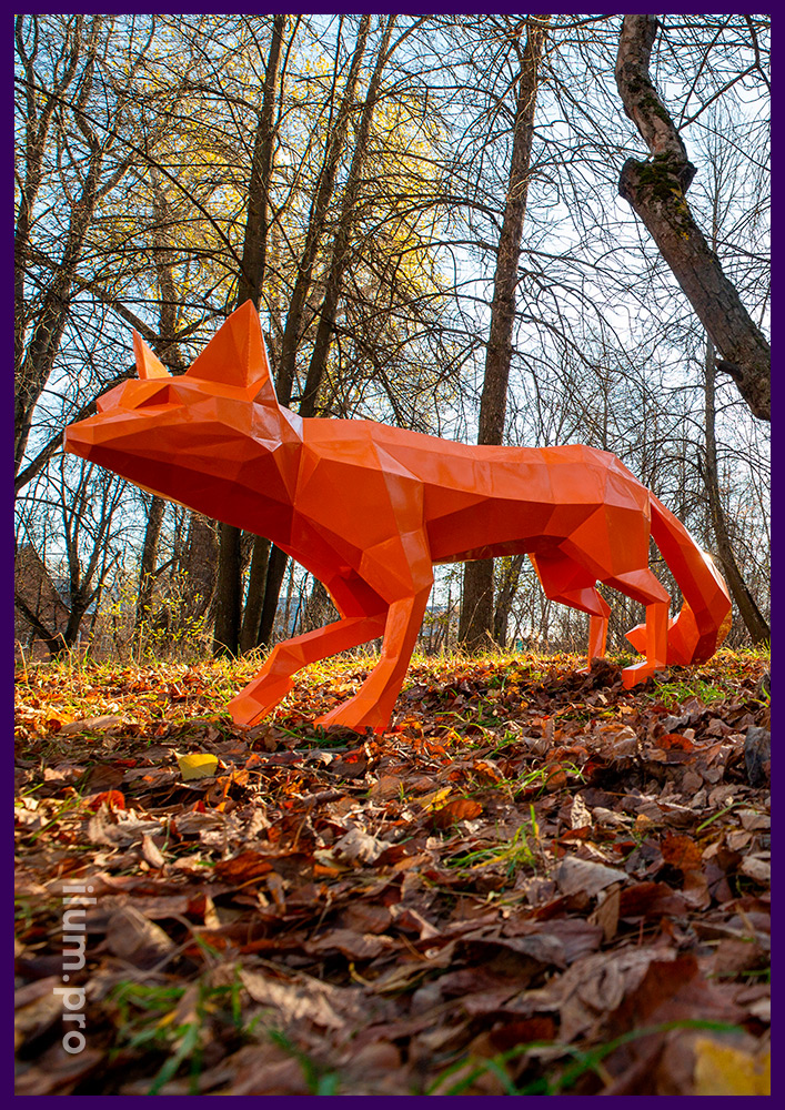 Полигональная фигура лисы оранжевого цвета из крашеной порошком стали в парке