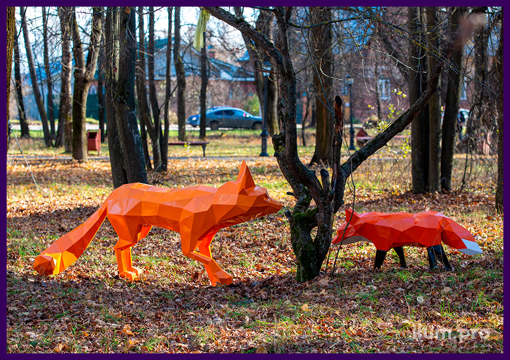 Полигональные, ландшафтные скульптуры в городском парке - лисы разных размеров и цветов