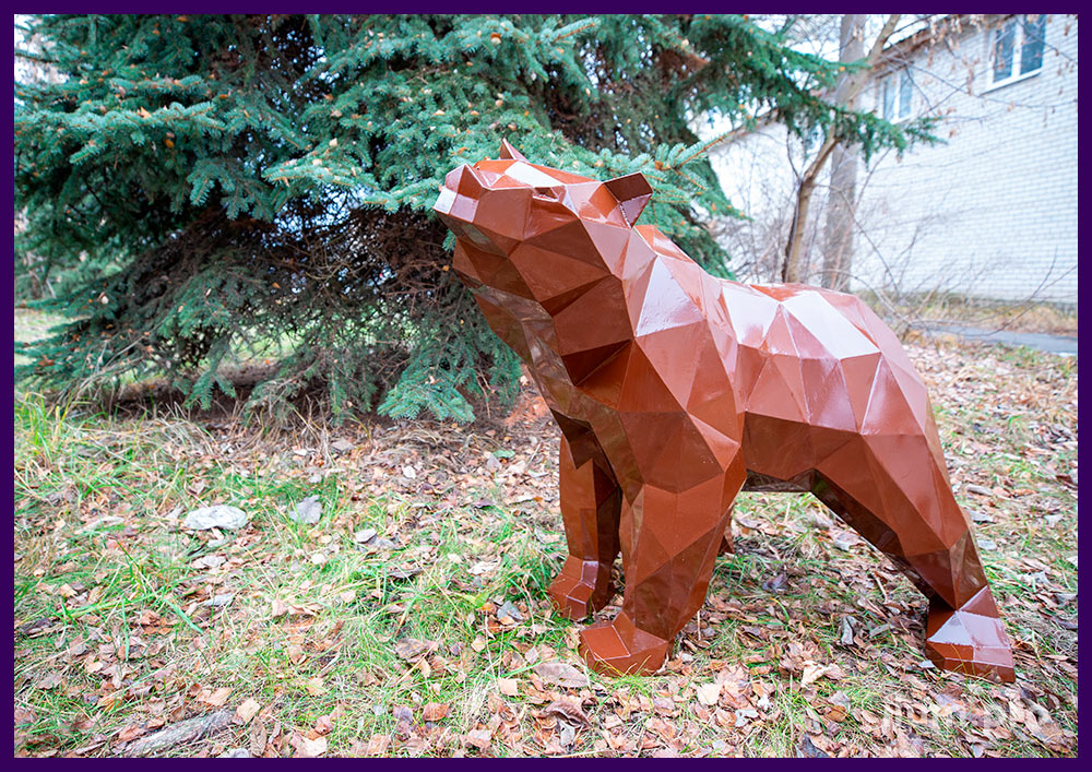 Скульптура металлического полигонального медвежонка коричневого цвета под ёлкой