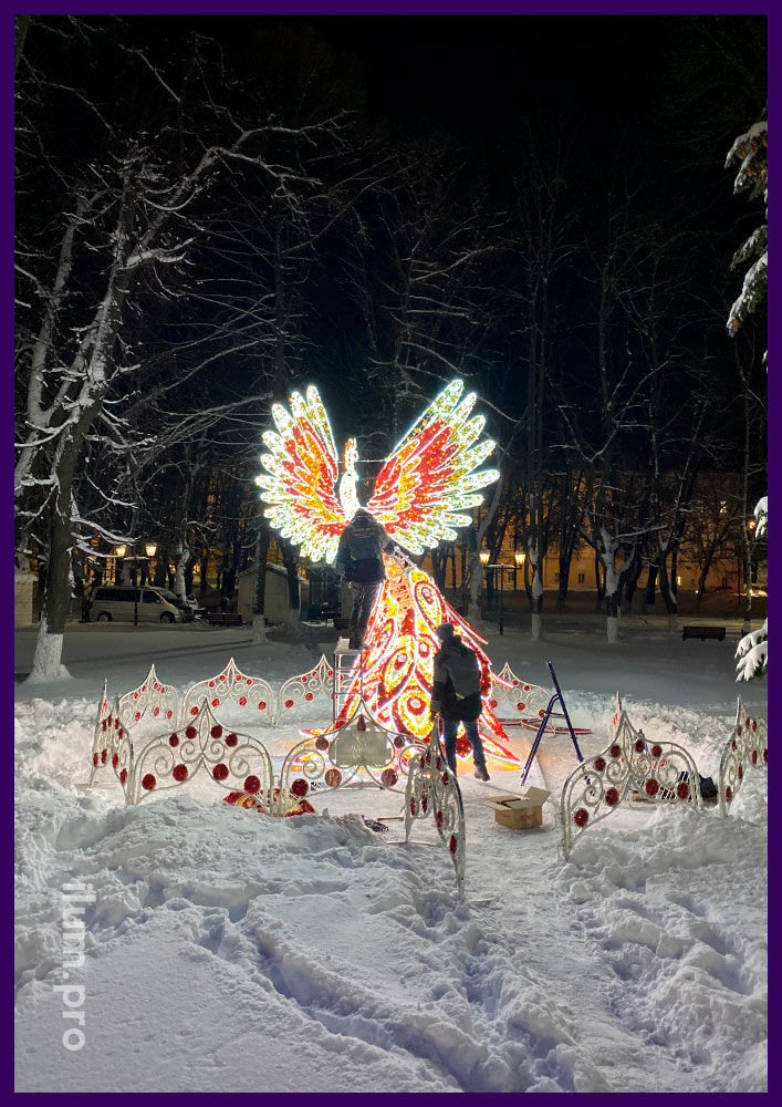 Новогоднее украшение городского парка светодиодной жар-птицей с белым дюралайтом, разноцветными гирляндами и блестящей мишурой