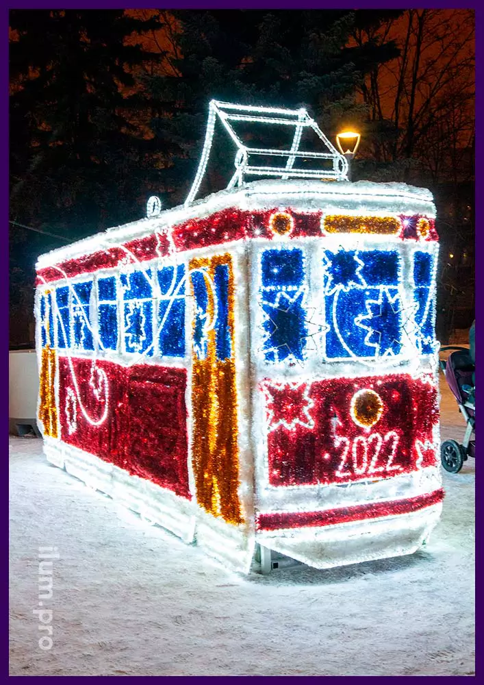 Трамвай светящийся из металлического каркаса, уличных гирлянд и разноцветной мишуры
