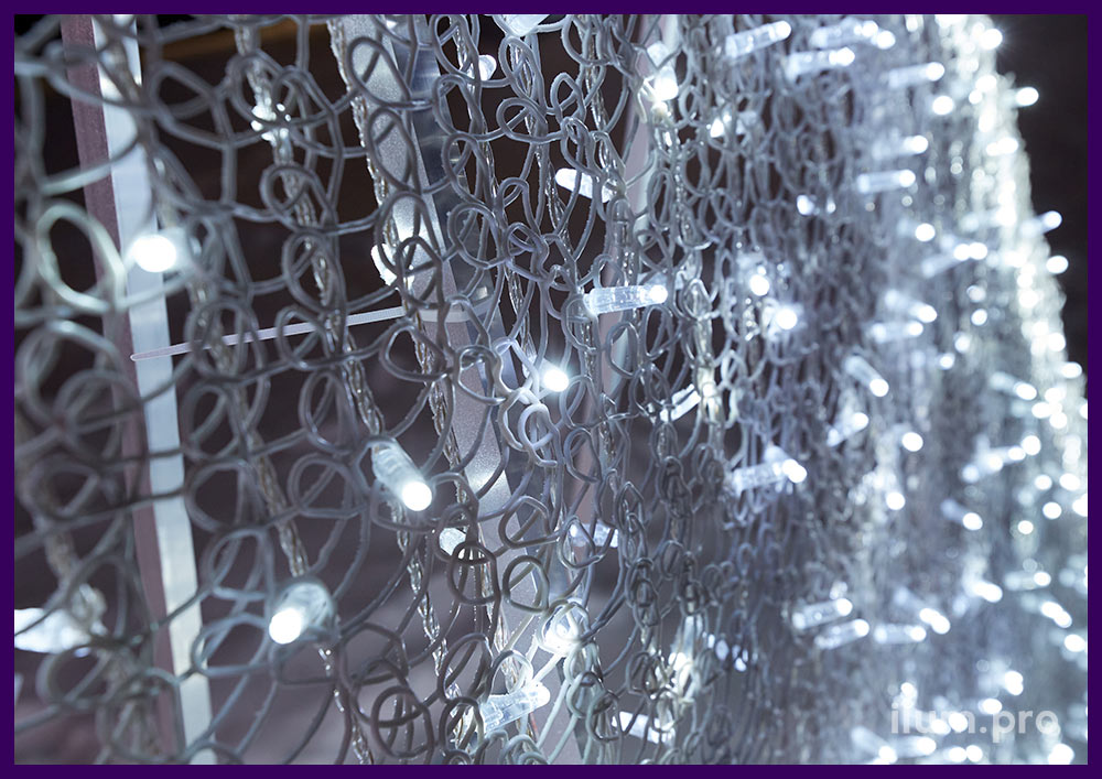 Декоративная ПВХ сетка на светодиодной фотозоне в городском сквере, подсветка уличными гирляндами