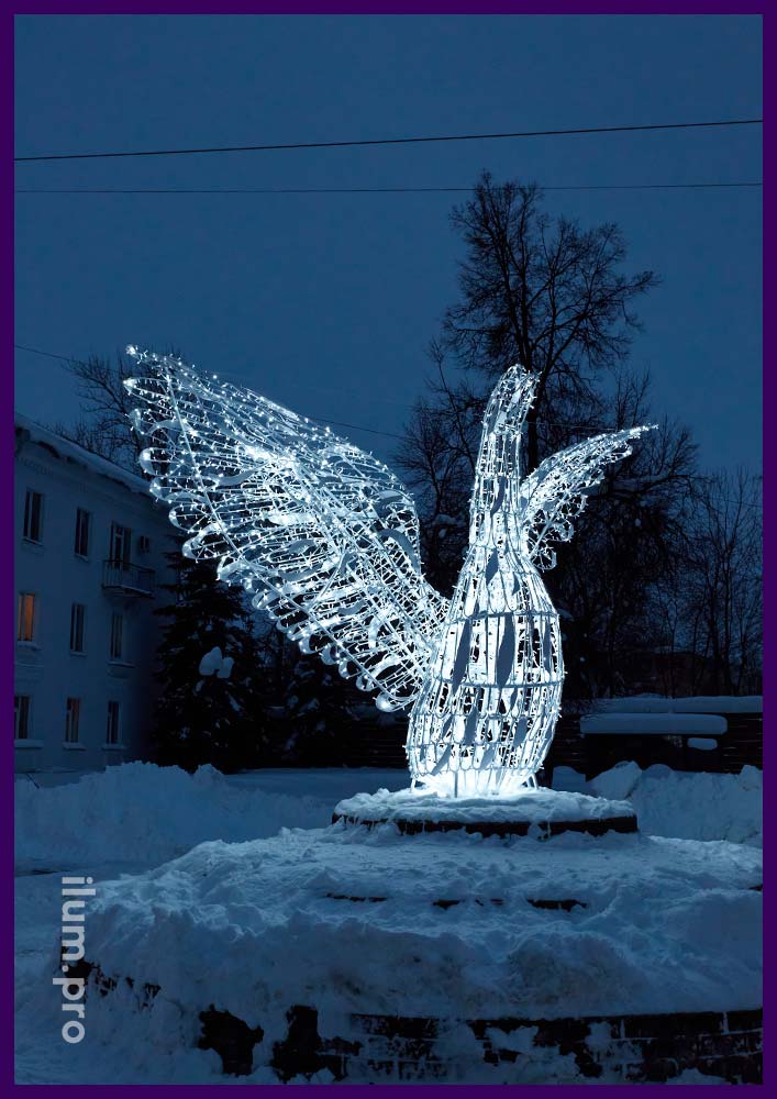 Большая белая птица с гирляндами и распростёртыми крыльями в центре города Гусь-Хрустальный