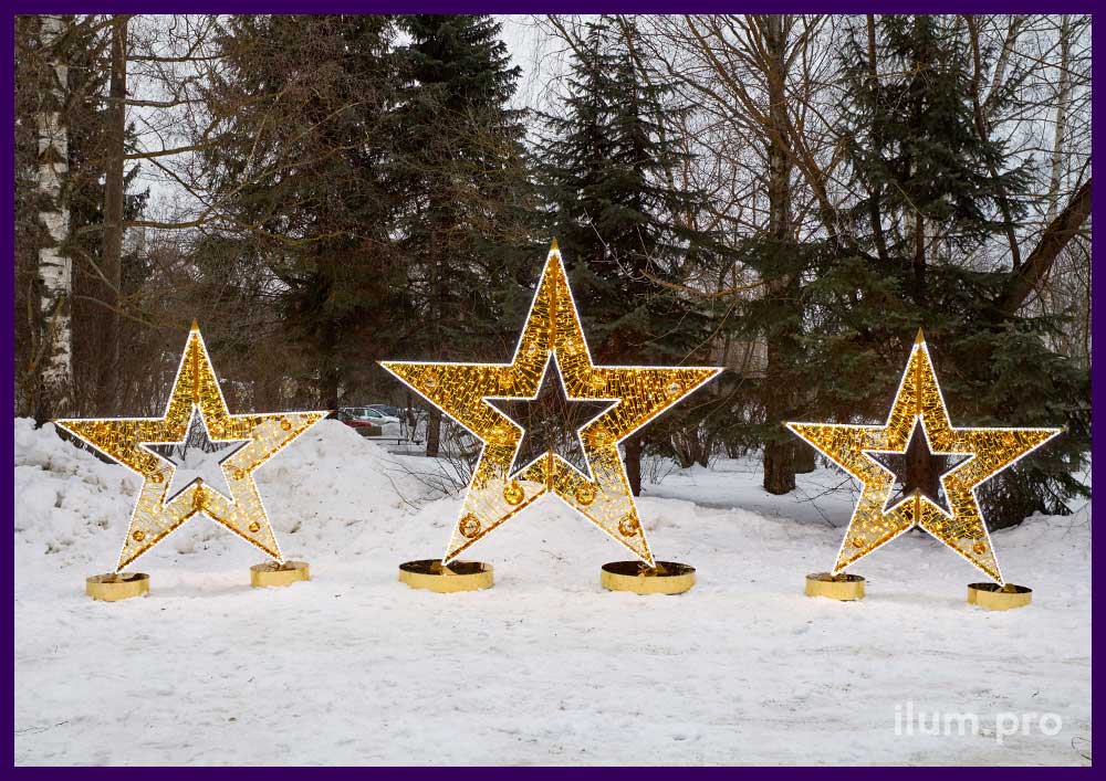 Фотозона с уличными гирляндами в форме трёх золотых звёзд разных размеров