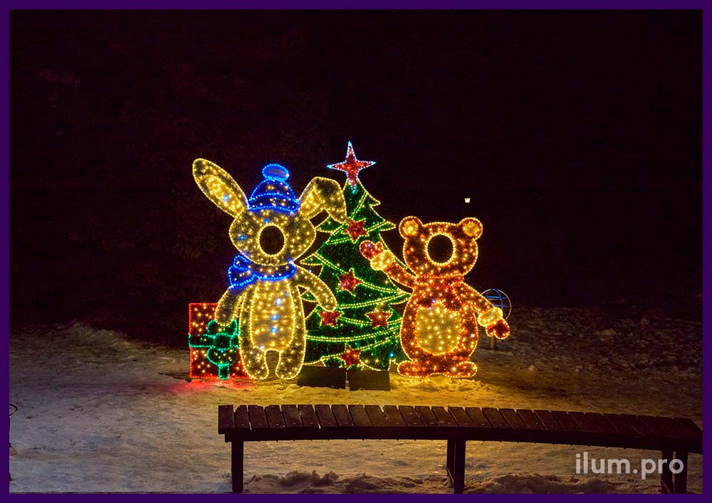 Новогодняя тантамареска в виде зайца и медведя рядом с ёлкой на городской площади на праздники
