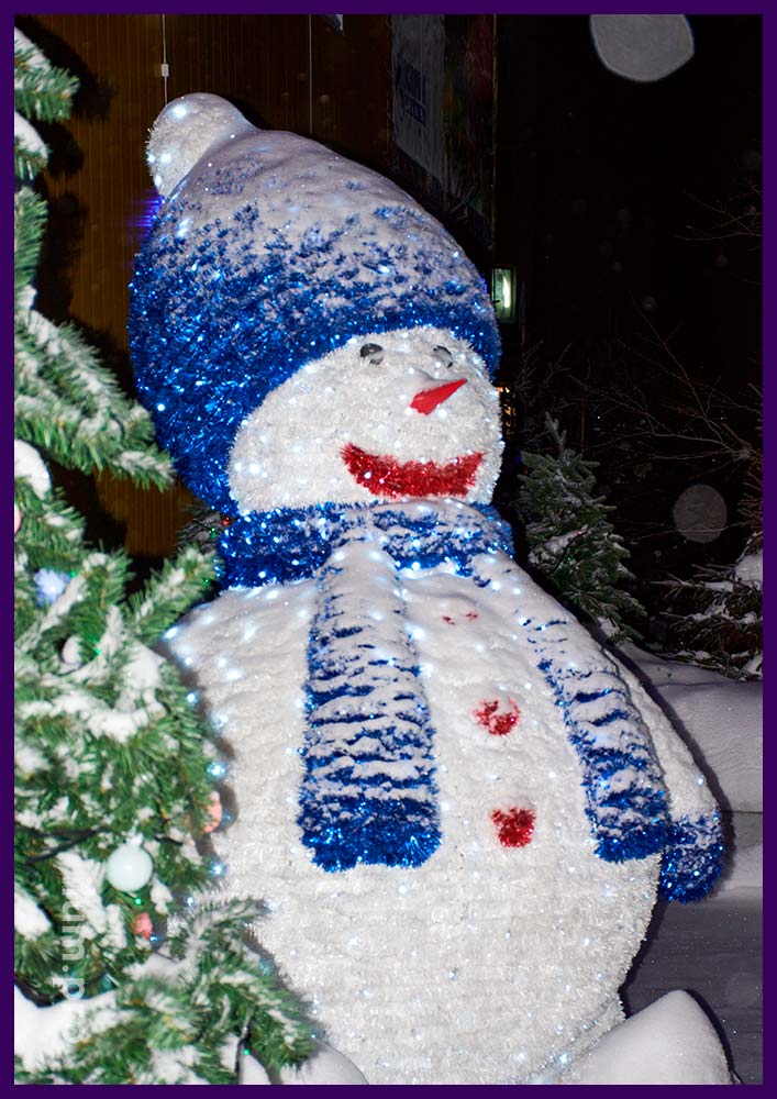 Большая фигура снеговика с подсветкой гирляндами и пушистой мишурой белого и синего цвета в Надыме