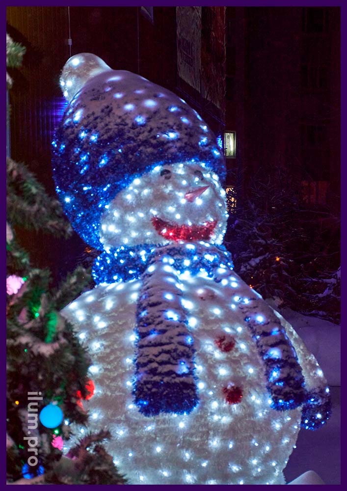 Разноцветный светодиодный снеговик с уличными гирляндами и ковром из белой и синей мишуры в Надыме