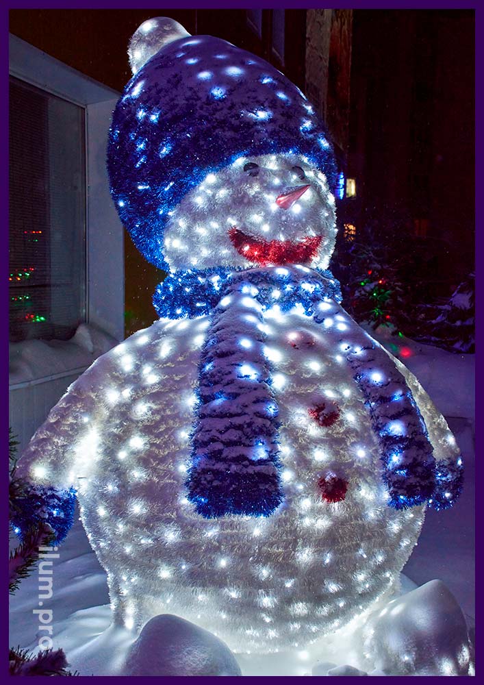 Бело-синяя фигура снеговика из гирлянд, нержавеющего каркаса и блестящей мишуры около офиса на Новый год