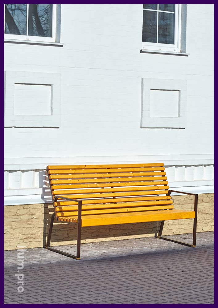 Уличная скамейка из дерева и металла, установленное в городском сквере для благоустройства