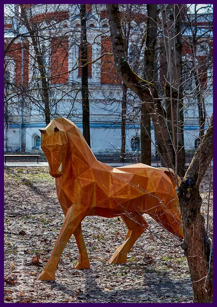 Фигура полигональная в форме лошади из ржавого кортена на газоне, в городском парке