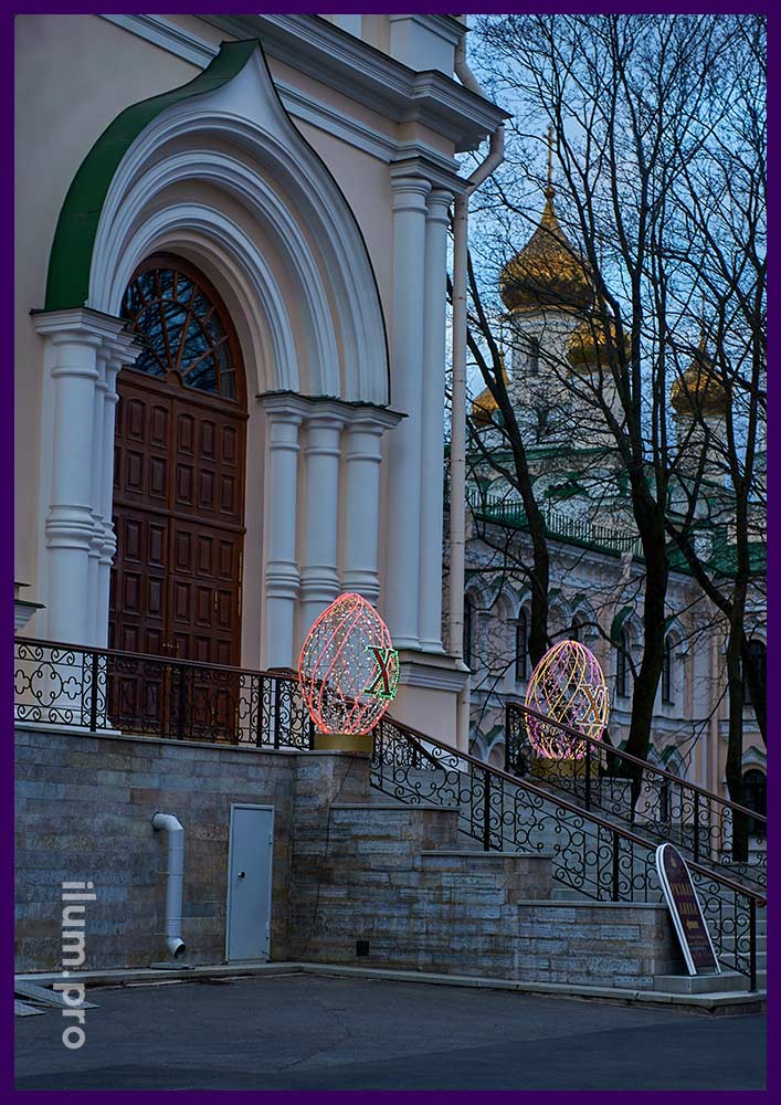 Украшение лестницы монастыря в Санкт-Петербурге на Пасху светящимися яйцами с гирляндами разных цветов