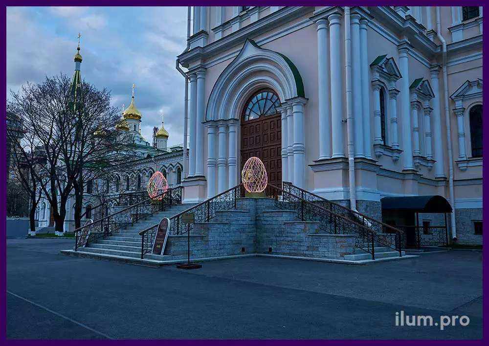 Пара светящихся яиц из гирлянд на металлическом каркасе в Санкт-Петербурге в монастыре