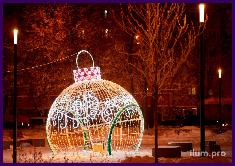 Уличные декорации на Новый год с гирляндами и мишурой - гигантский шар в форме ёлочной игрушки
