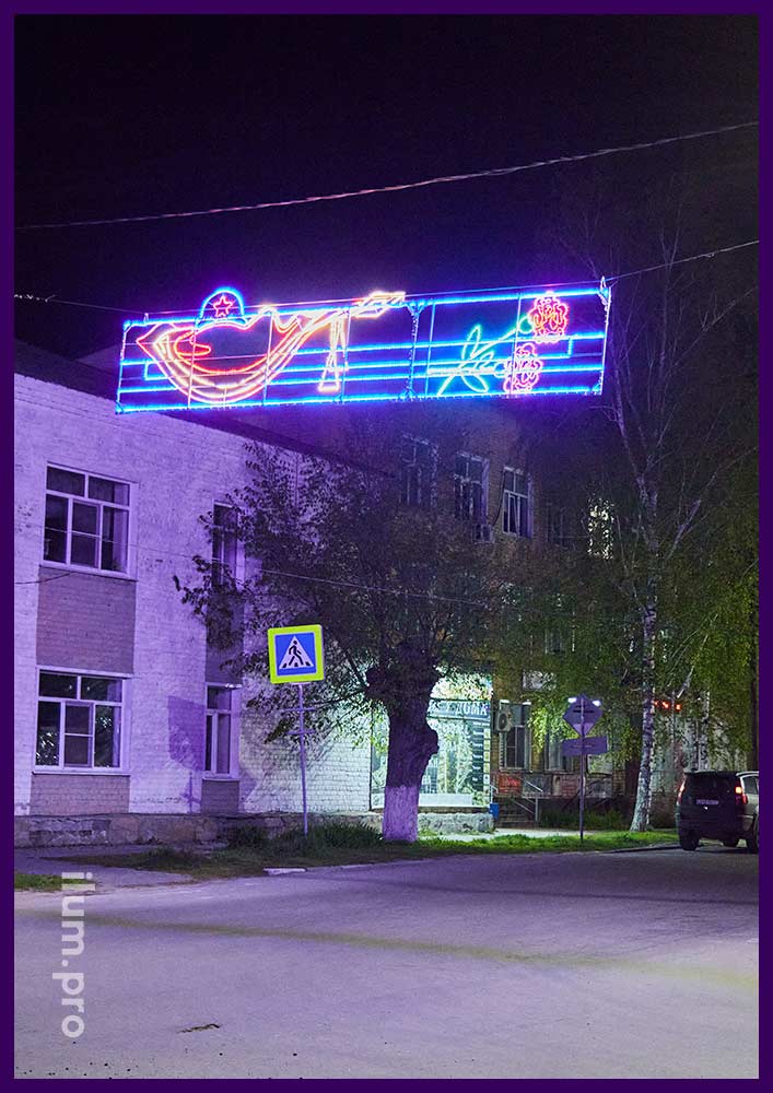 Уличные светодиодные консоли над дорогой города в форме гвоздик и каски на День Победы