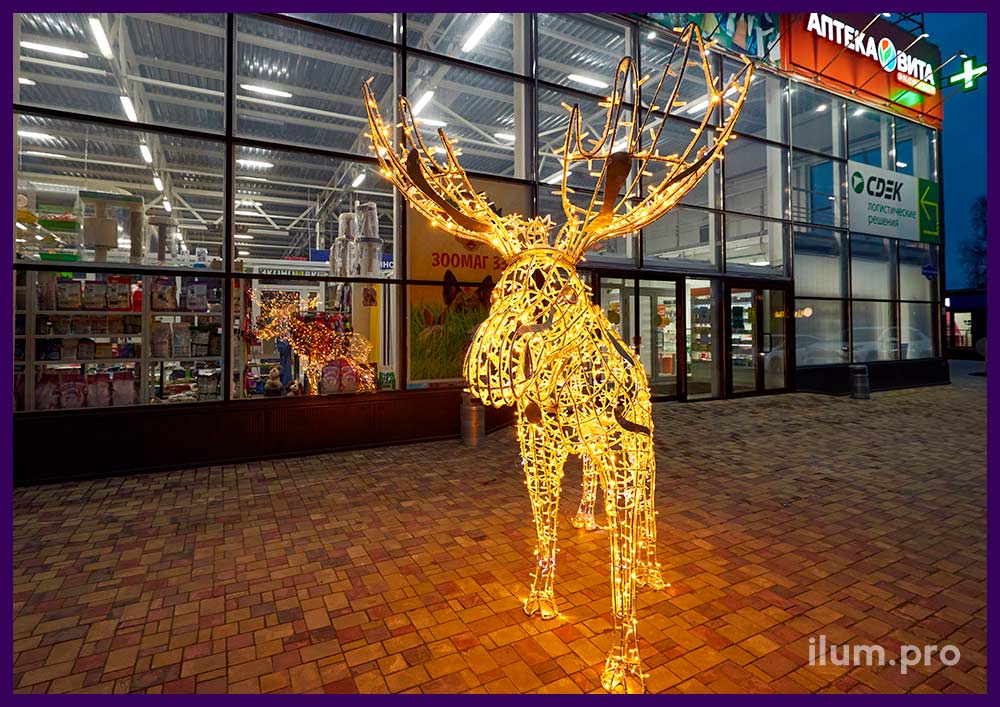 Фотозона рядом с торговым центром в виде светящейся фигуры лося с гирляндами