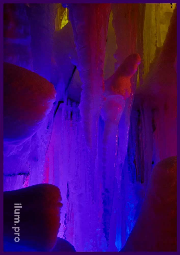 Разноцветная ёлка изо льда в парк-отеле, конструкция с прожекторами и гирляндами