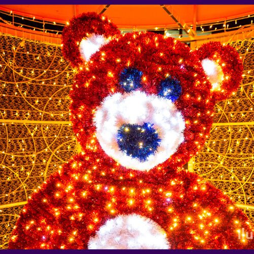 Разноцветный подарок с медведем из мишуры и гирлянд, бант из красной сетки ПВХ для улицы