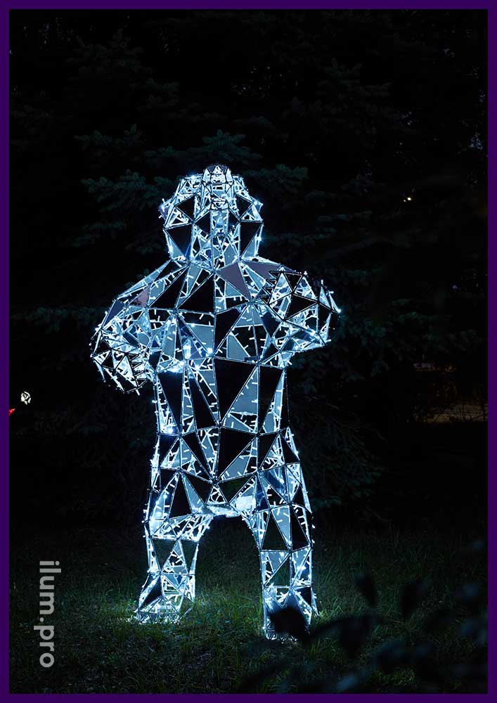Украшение парка металлической полигональной скульптурой медведя с зеркальными гранями серебряного цвета и иллюминацией