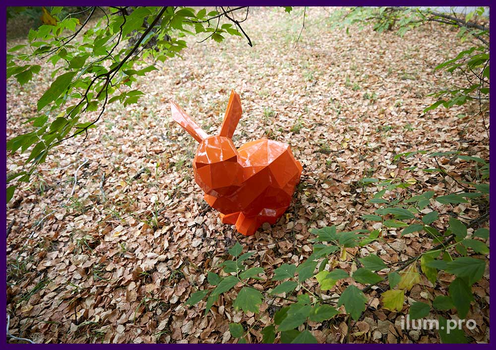 Заяц полигональный оранжевого цвета, оттенок сигнальный, установленный в парке
