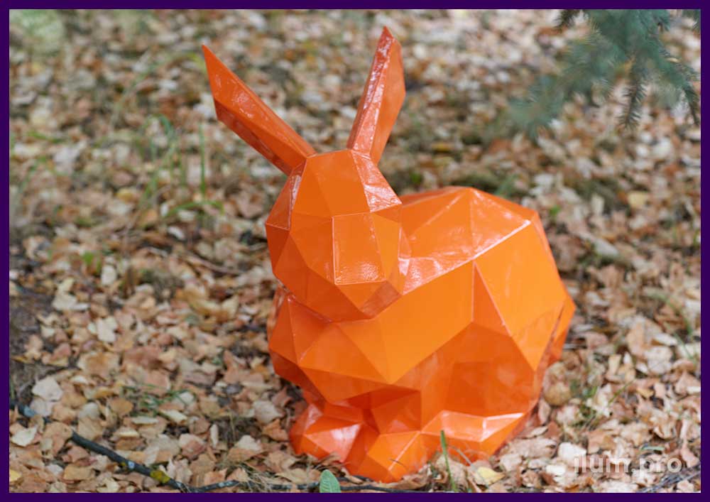 Украшение парка оранжевой полигональной фигурой зайца из крашеной стали